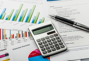 Pen and Calculator on Business Graphs and Charts