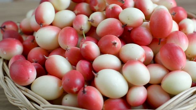Karanda fruit on basket with senior hand, healthy fruit concept.