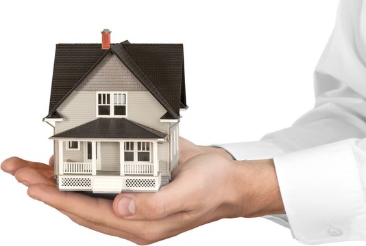 Men's Cupped Hands Holding a Model of a House - Isolated