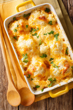 Casserole from cauliflower with cheese sauce close-up in a baking dish. Vertical top view
