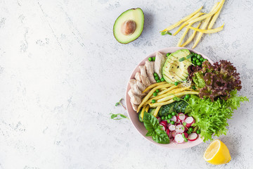 Salad with chicken breast with asparagus beans, radish, avocado, cucumber and lettuce on white background