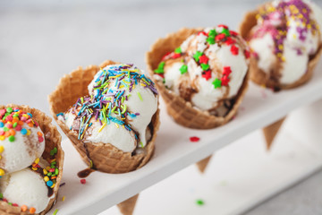 ice cream in cone with confectionery powder on stand over white background