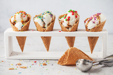 ice cream in cone with confectionery powder on stand over white background