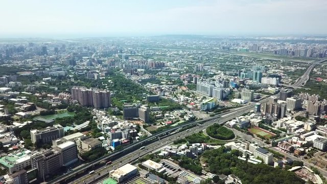 Aerial shot rotating over a busy freeway and buildings in the metropolis of Hsinchu City, Taiwan.