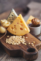 Obraz na płótnie Canvas pine nuts on a wooden board and cheeses