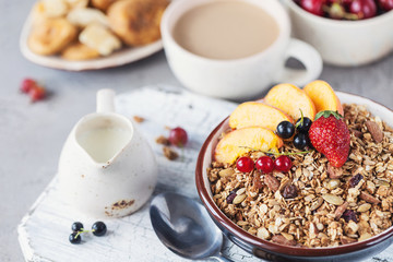 Healthy breakfast with granola and dried fruit, fresh fruit. Cup of coffee with milk