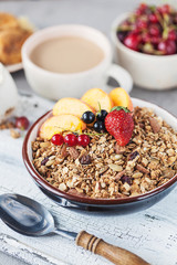 Healthy breakfast with granola and dried fruit, fresh fruit. Cup of coffee with milk