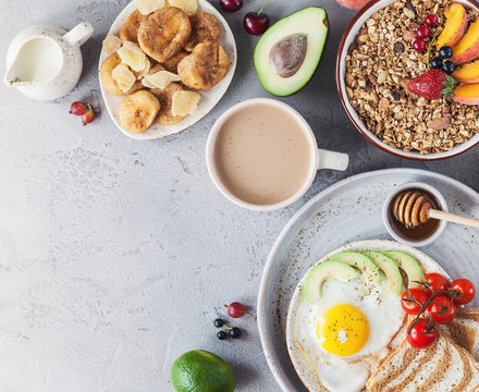 Healthy breakfast with granola and dried fruit, fresh fruit. Fried egg
and cup of coffee with milk