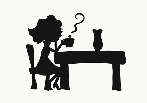 Woman sitting at a table and blowing on steam over a cup