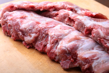 Raw Ribs on a rustic cutting board with salt, pepper and grinder for spices . copy space. Top View.
