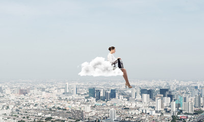 Fototapeta na wymiar Businesswoman or accountant on cloud floating high above modern city