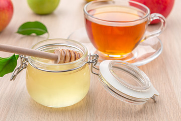 Jewish holiday Rosh Hashanah background with honey and apples on wooden table.
