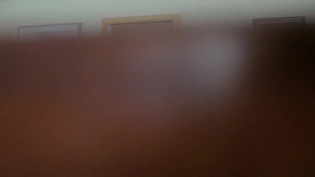 Smooth downward pan of an acoustic guitar against a dark background. Ends with a solid brown frame, allowing for a seamless transition to another clip.
