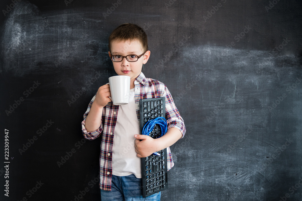 Wall mural young boy's standing with keyboard and network wire near blackboard. young programmer or system admi