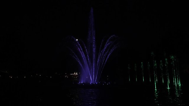 Fountain colored water show. Colorful fontain light in city. Pokaz kolorowych swiatel fontanny w nocy, Warszawa.