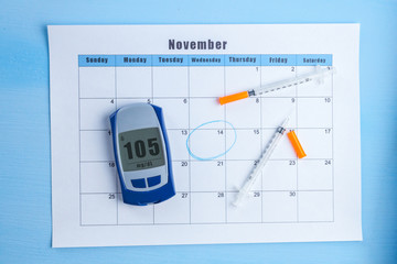 Glucometer and the injections for insulin lie on the calendar. World Diabetes Day, 14 November. Diabetes concept. Sugar diabetes