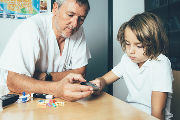 Obraz premium Doctor and diabetic child measuring sugar level