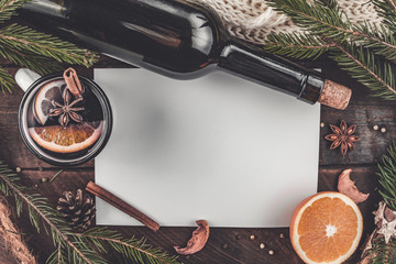 Mug of hot mulled wine with spices, citrus fruits, cinnamon and anise stars on a wooden background. Copy space. Top view. Flat lay. Mulled wine background. Winter drinks. Christmas, cozy evening