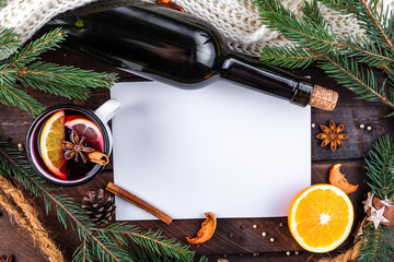 Mug of hot mulled wine with spices, citrus fruits, cinnamon and anise stars on a wooden background. Copy space. Top view. Flat lay. Mulled wine background. Winter drinks. Christmas, cozy evening