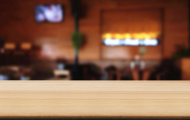 Empty wooden table and blurred background of abstract in front of coffee shop or restaurant for display of product or for montage