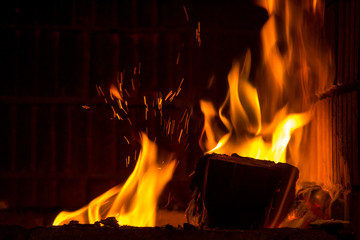 Obraz premium Burning firewood with flame tongues and spark in the fireplace