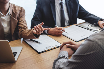 Two senior manager reading a resume during a job interview, Employer interviewing to ask young male...