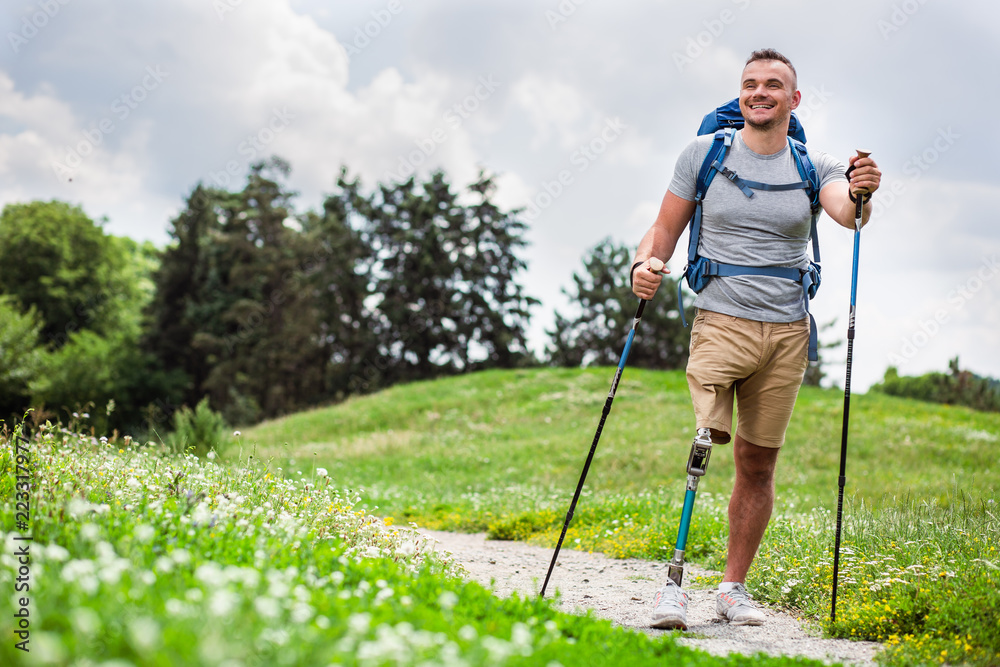 Wall mural Happy young man with disability trying Nordic walking