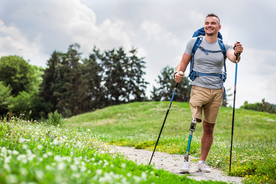 Happy young man with disability trying Nordic walking