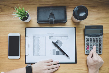 Businessman working on a graph document financial report and analysis calculation cost with...