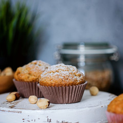 Homemade muffins decorated with sugar powder, hazel nuts