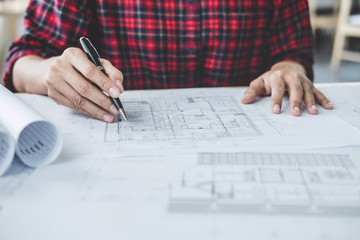 Construction and structure concept, Hands of architect or engineer working for new project plan on blueprint, model building and engineering tools in working site