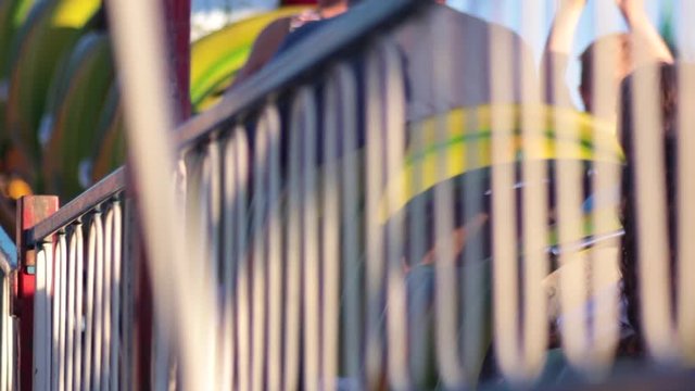 Close up of kids riding carnival rollercoster up track blurry
