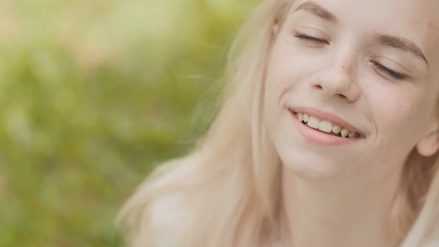 Close-up face of a smiling 19 year old blonde girl.