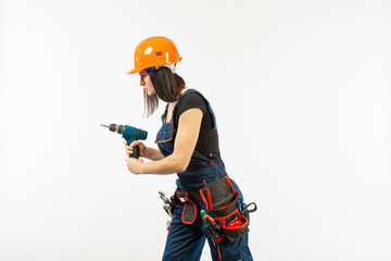 Young woman with toolbelt using driil and some power tools for her work at home. Girl working at flat remodeling. Building, repair and renovation.