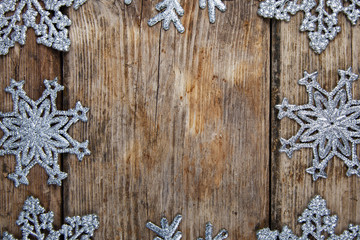 Silvery snowflakes on a wooden background