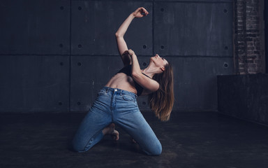young beautiful woman in top and jeans dancing modern contemporary dance in the studio, contemporary art, harmony of body and soul, professional dancer