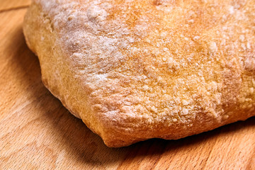 Traditional italian wheat bread ciabatta  on a wooden table. Closeup