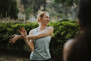 Obraz premium Friends stretching together in the park