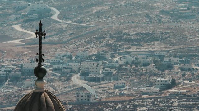 Bethlehem, Palestine, West Bank, Israel. Big closeup view, for a Bethlehem Church tower, houses in the distance, sunny morning. 4K footage
