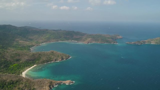 Aerial view of coast with beaches, island Limbones, lagoons and coral reefs. Neela cove, Philippines, Luzon. Coast ocean with turquoise water. Tropical landscape in Asia.