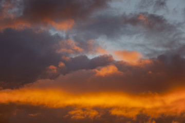 Naklejka na ściany i meble Gloomy sky after the rain in sunlight at sunset, Sky After sunset -Red background