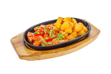 Potatoes with meat, pork, chicken, bell pepper and green onion, with sweet and sour sauce, fried, baked portion on a hot frying pan, on a wooden board on a white background Side view. For the menu