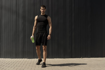Athletic modern young man posing on a gray metallic wall copy sp