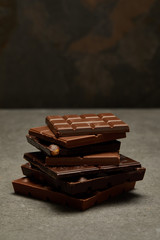 close-up view of sweet assorted stacked chocolate bars on grey