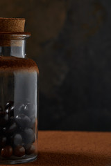 Obraz na płótnie Canvas close-up view of gourmet chocolate balls in glass jar and cocoa powder on dark background