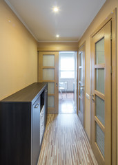 Interior of the flat. Warm tones, wooden floor. Hallway furniture.