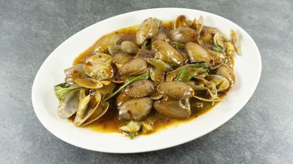 Thai food. Stir fried clams with roasted chili paste on stone background. Top view, Copy space for design. .