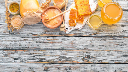 Set of bee products and honey on a white wooden background. Free space for text. Top view.