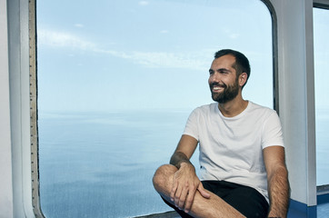 Fototapeta na wymiar Handsome man smiling on the deck of a ship during holidays.