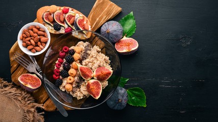 Oatmeal porridge with figs, raspberries, blackberries and chia seeds. Healthy food. Free space for text. Top view.